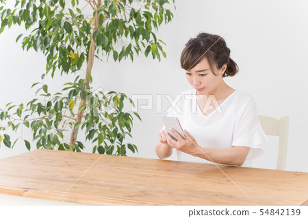 A woman happy to see a smartphone 54842139