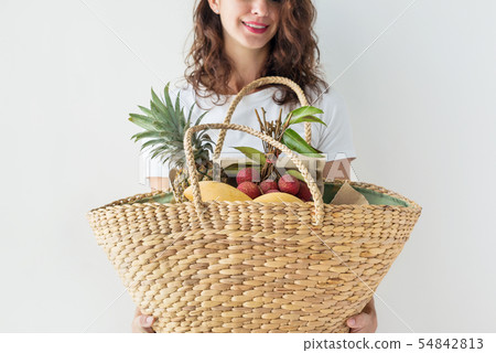 Young woman stands wattled bag near wall kinfolk. Young woman stands wattled bag near wall kinfolk. 54842813