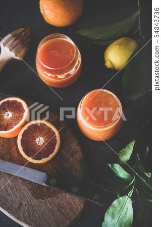 Orange juice in glasses and fresh citrus fruits 54843736