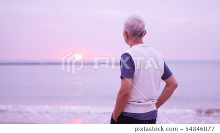 Asian senior man standing alone at sunrise morning 54846077