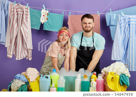 man and woman washing dirty clothes in the bowl with foam man and woman washing dirty clothes in the bowl with foam 54847459