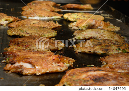 Delicious okonomiyaki being cooked Delicious okonomiyaki being cooked 54847693