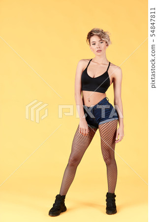 Sexy athletic woman in black top, shorts tights in the net posing to the camera Sexy athletic woman in black top, shorts tights in the net posing to the camera 54847811
