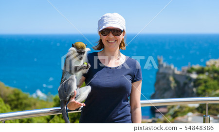 Young woman posing with a monkey on the Black Sea Young woman posing with a monkey on the Black Sea 54848386