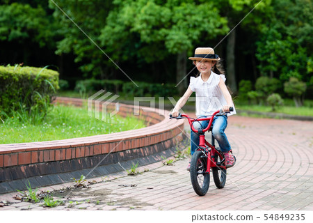 A girl playing with a bicycle 54849235