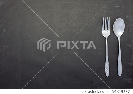 Stainless steel spoon and fork on black wood Stainless steel spoon and fork on black wood 54849277