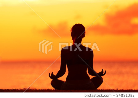 Wellness woman doing zen yoga meditation on beach 54851382