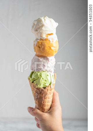 hand holding four scoops of ice cream in waffle hand holding four scoops of ice cream in waffle 54851803