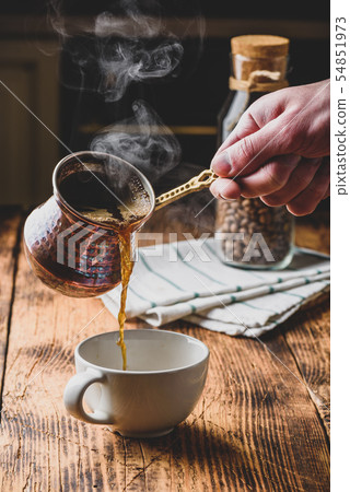 Pouring turkish coffee into white cup 54851973