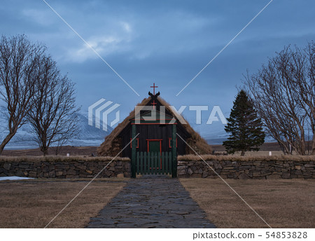 A paved road to a gate in front of a small church A paved road to a gate in front of a small church 54853828
