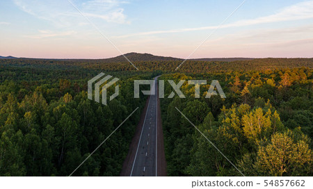 Top view of the dirt road and green spring forests in bright sunset colors. Beautiful landscape from Top view of the dirt road and green spring forests in bright sunset colors. Beautiful landscape from 54857662