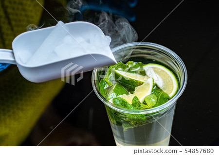 Cocktail with ice vapor on bar desk, close-up. dry ice. Cocktail with ice vapor on bar desk, close-up. dry ice. 54857680