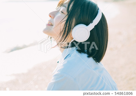 High school girl listening to music at sea 54861806