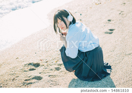 High school girl listening to music on the beach 54861810