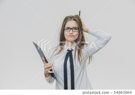 Adorable caucasian business woman is holding black paper holder or clipboard and looking at the Adorable caucasian business woman is holding black paper holder or clipboard and looking at the 54863064