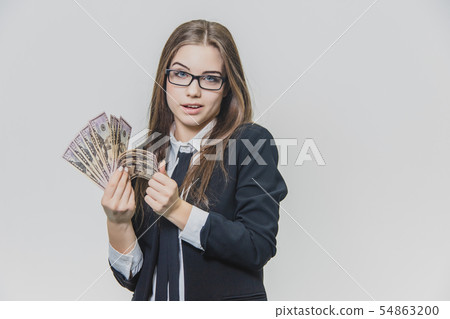 Concentrated young business woman is counting a pile of money, isolated on white background. Girl is 54863200