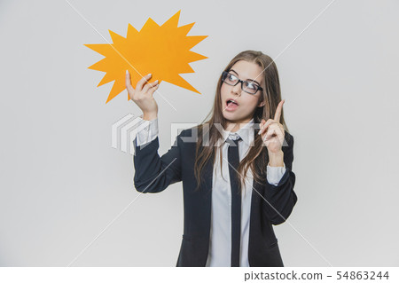 Young woman is holding a orange speech bubble, which is star-shaped, isolated, on the white Young woman is holding a orange speech bubble, which is star-shaped, isolated, on the white 54863244