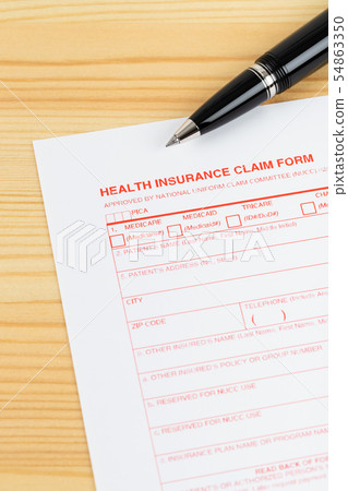 Health insurance claim form with pen on wooden 54863350