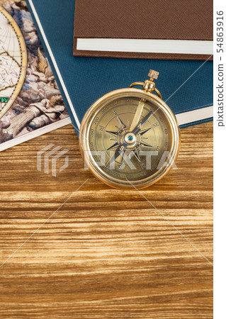 Compass on wooden background with vintage book and Compass on wooden background with vintage book and 54863916