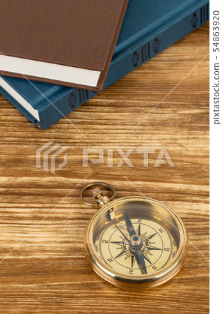 Compass on wooden background with vintage book, Compass on wooden background with vintage book, 54863920