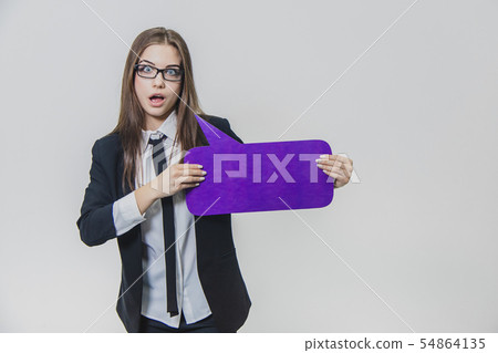 Young business woman is holding a violet speech bubble closse to herself, which is rectangular Young business woman is holding a violet speech bubble closse to herself, which is rectangular 54864135