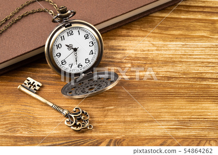 Vintage pocket watch clock with key and book on Vintage pocket watch clock with key and book on 54864262