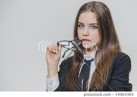 Charming sexy young businesswoman is holding glasses near her slightly open mouth. Girl has her body Charming sexy young businesswoman is holding glasses near her slightly open mouth. Girl has her body 54864365
