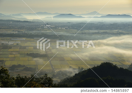 The morning misty Kanto plain seen from the large and small mountain south side peaks and the distant Mt. Mitaka and Mt. Tsukuba The morning misty Kanto plain seen from the large and small mountain south side peaks and the distant Mt. Mitaka and Mt. Tsukuba 54865897