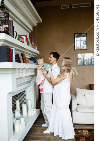 Tender family hugs. Happy pregnant mom, dad holds the baby in his arms at home 54866541