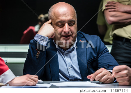 Man answering the questions of the prosecutor during an official interrogation 54867554