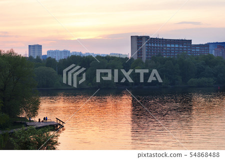 People on the river bank admire the expressive 54868488