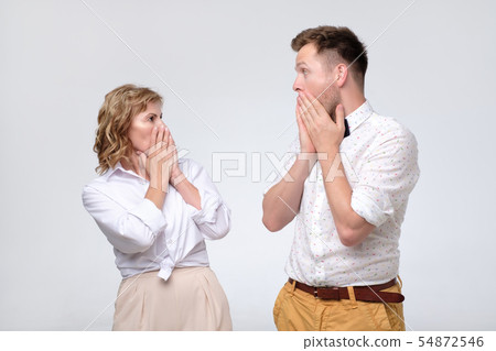 Surprised young man and mature woman looking at each other in full disbelief Surprised young man and mature woman looking at each other in full disbelief 54872546