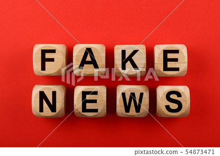 Wooden cubes with FAKE NEWS words over red 54873471