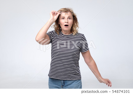 Attractive lovely pretty mature lady opened mouth touching glasses amazed with price. 54874101