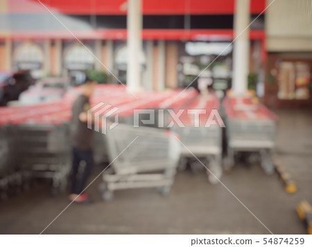 blurred image of people taking a shopping carts or 54874259