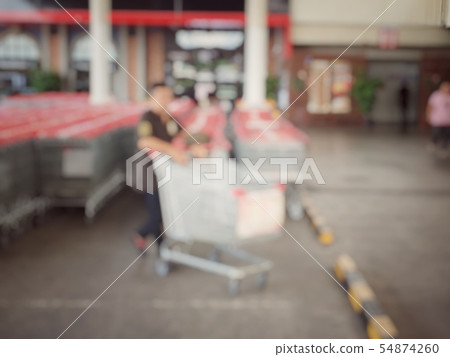 blurred image of people taking a shopping carts or 54874260