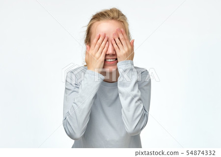 Young woman covering eyes with hands expecting to see surprise on your birthday. 54874332