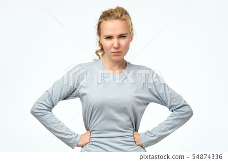 Displeased angry teenager holding hands on hips, frowning, looking with contempt Displeased angry teenager holding hands on hips, frowning, looking with contempt 54874336