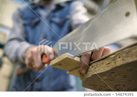 Sawing a wooden board with special japanese hand saw or hacksaw during carpentry Sawing a wooden board with special japanese hand saw or hacksaw during carpentry 54874391