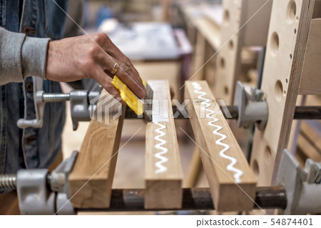 Apply the adhesive on a wooden surface Apply the adhesive on a wooden surface 54874401