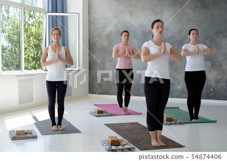 Young caucasian women working out indoors standing in Tadasana, Mountain Pose Young caucasian women working out indoors standing in Tadasana, Mountain Pose 54874406
