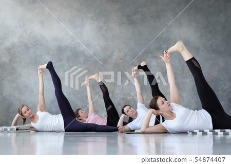 Group of several european women doing yoga posture anantasana. 54874407