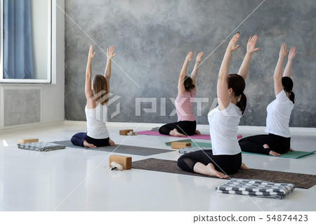 young women doing yoga exercise, lying in Hero pose, Virasana 54874423