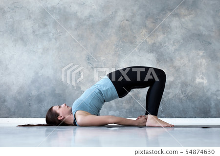Young woman in ardha chakrasana yoga pose Young woman in ardha chakrasana yoga pose 54874630