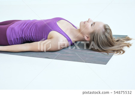 woman practicing yoga, lying in Savasana exercise, resting after yoga 54875532