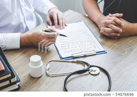 Doctor having conversation with patient while Doctor having conversation with patient while 54876696