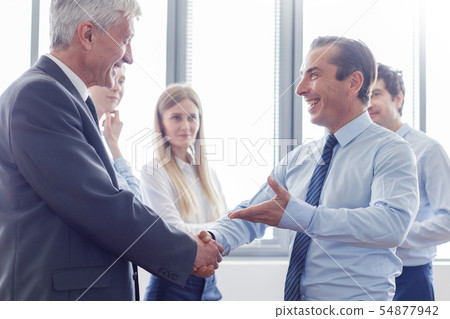 Happy business people shaking hands Happy business people shaking hands 54877942