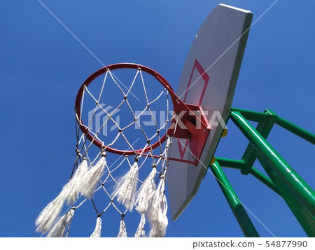 White and red basketball hoop photo on blue sky White and red basketball hoop photo on blue sky 54877990