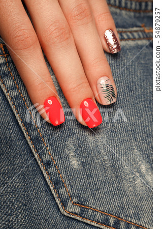 Bright neon red manicure on female hands on the background of jeans. Nail design. Beauty hands. Bright neon red manicure on female hands on the background of jeans. Nail design. Beauty hands. 54879257