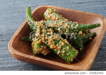 添加在一個木碗的芝麻籽秋葵在藍色背景 添加在一個木碗的芝麻籽秋葵在藍色背景 54882443